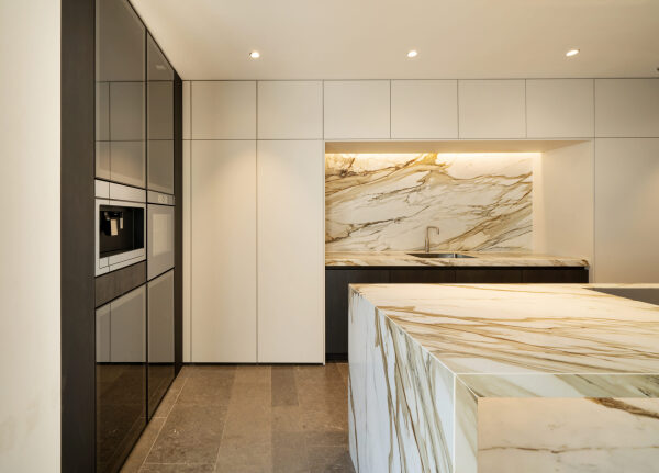 Keuken met marmeren werkblad, ingebouwde oven en strakke witte kasten