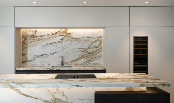 Moderne keuken met marmeren achterwand, ingebouwde spoelbak en wit keukenkasten